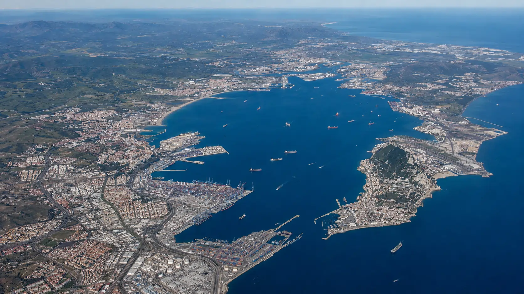 High altitude aerial view of the full Bay of Algeciras port complex showing the scale of operations across multiple terminals and basins